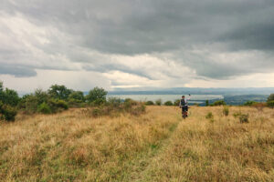 ciclista in mezzo a un campo che affaccia sul lago trasimeno