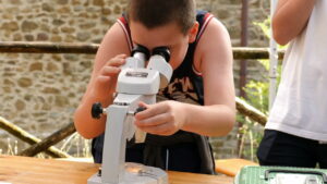 ragazzo che guarda in un microscopio